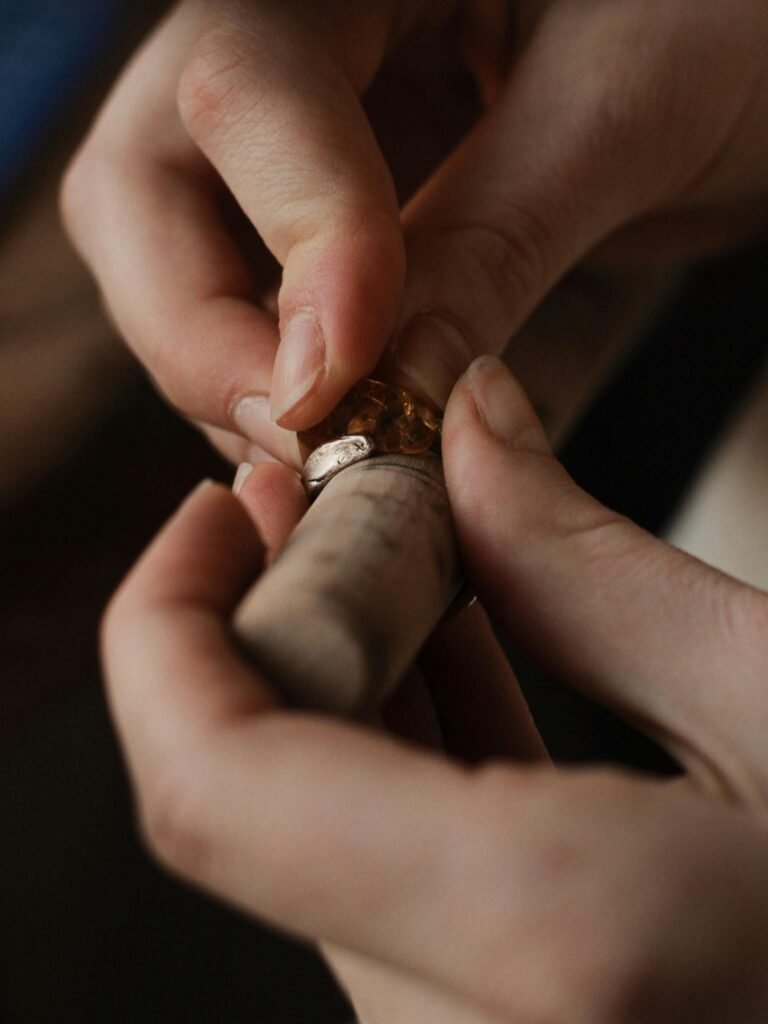 A detailed close-up of an artisan crafting a handmade ring with amber.