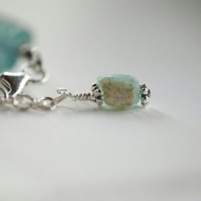 Close-up of a turquoise gemstone bracelet with silver detail, perfect for fashion and jewelry enthusiasts.
