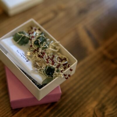 Close-up of handmade gemstone jewelry in a gift box, showcasing intricate craftsmanship and design.